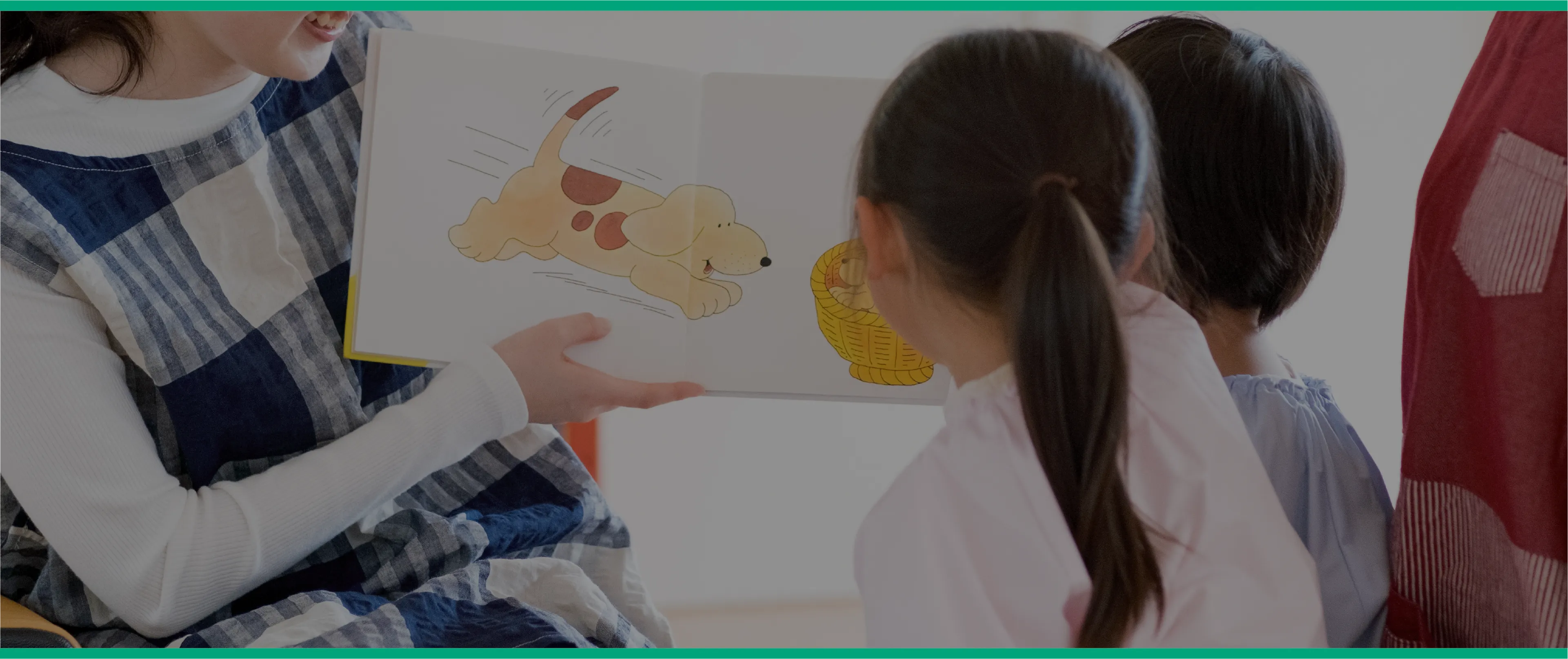 スタッフと一緒に絵本を楽しむ子どもたち